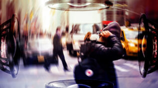 motion blurred image of a man covering his ears in a busy noisy city